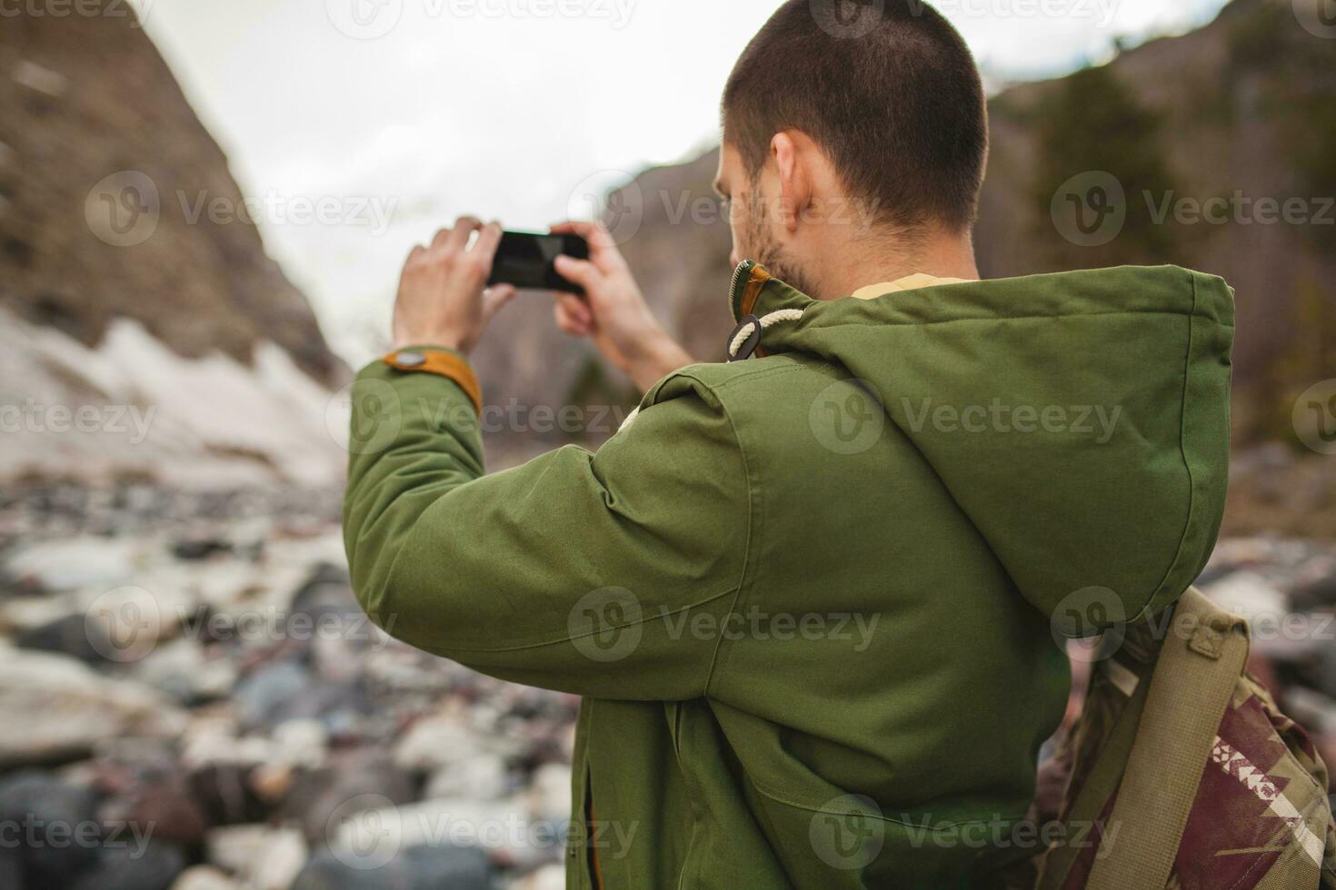 young hipster man hiking in mountains photo