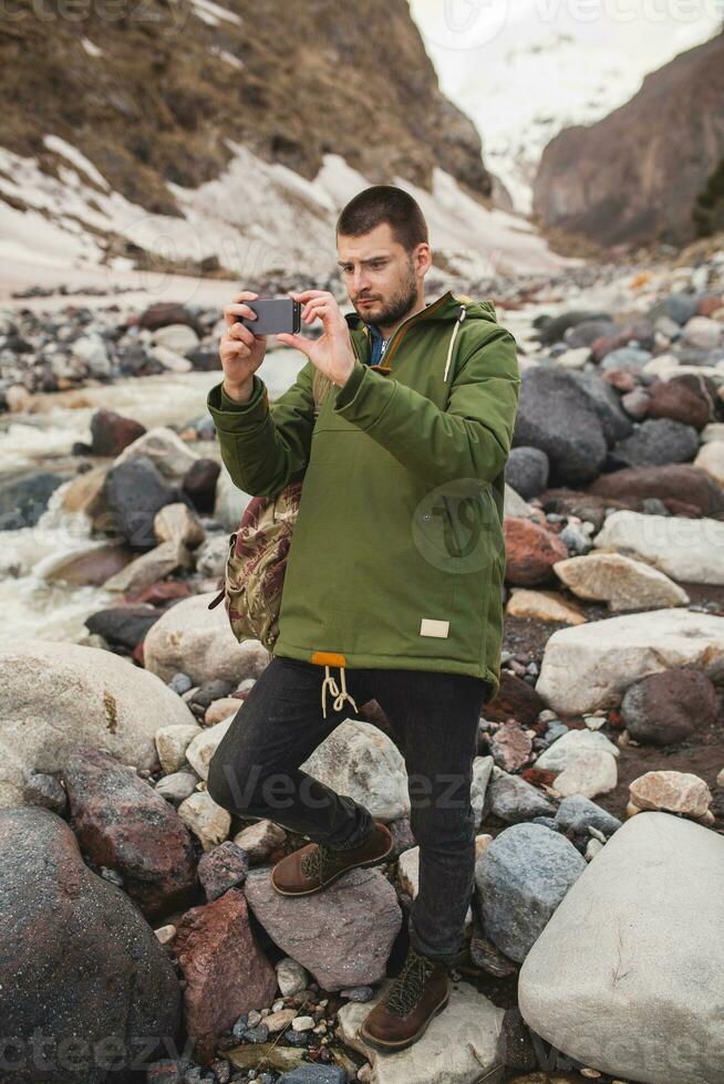 young hipster man hiking in mountains photo