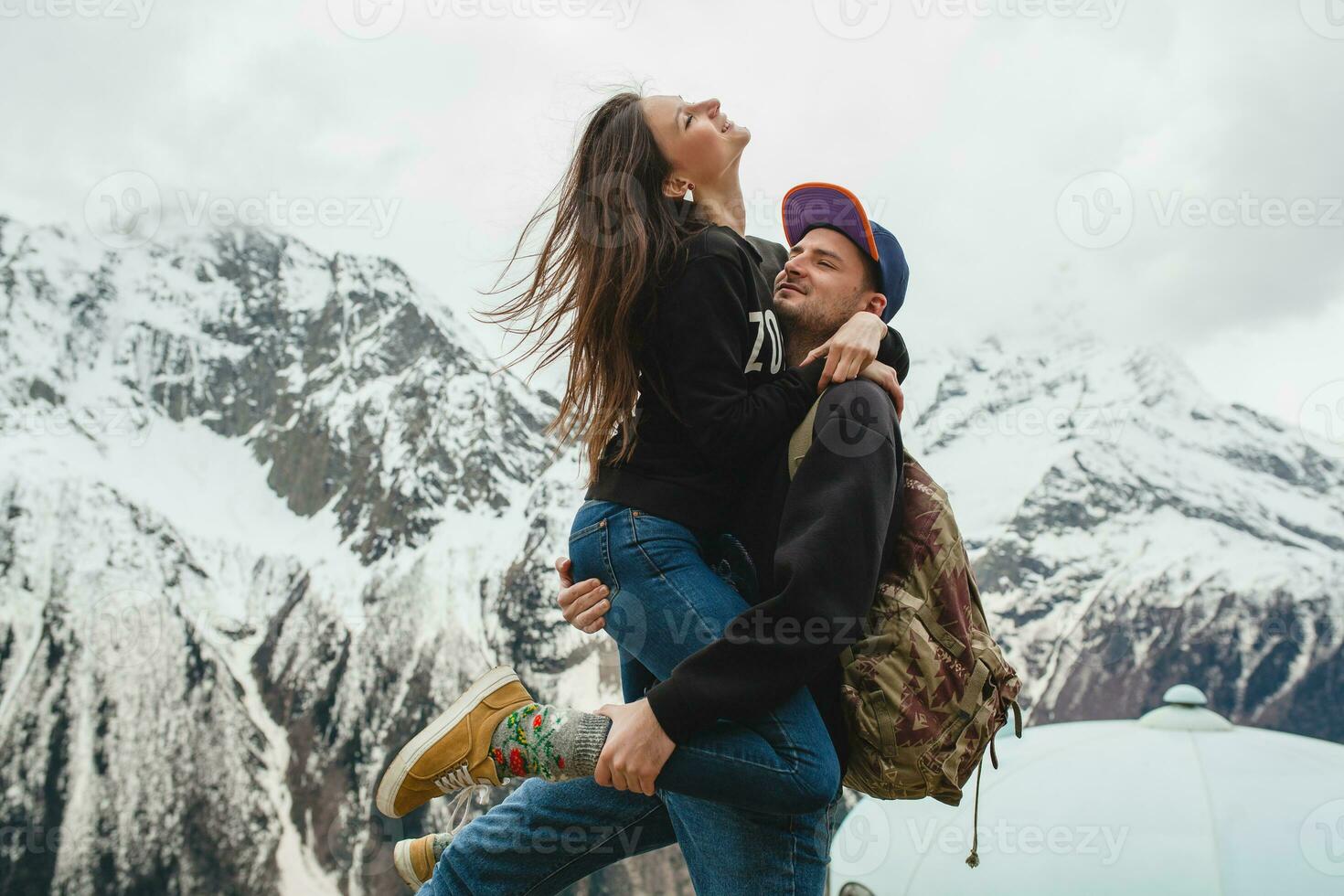 young hipster couple in love on winter vacation in mountains photo