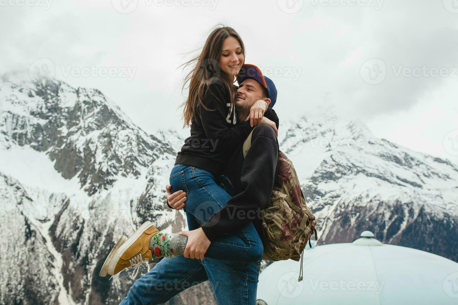 young hipster couple in love on winter vacation in mountains photo