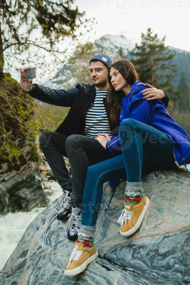 young hipster couple in love walking in mountains photo