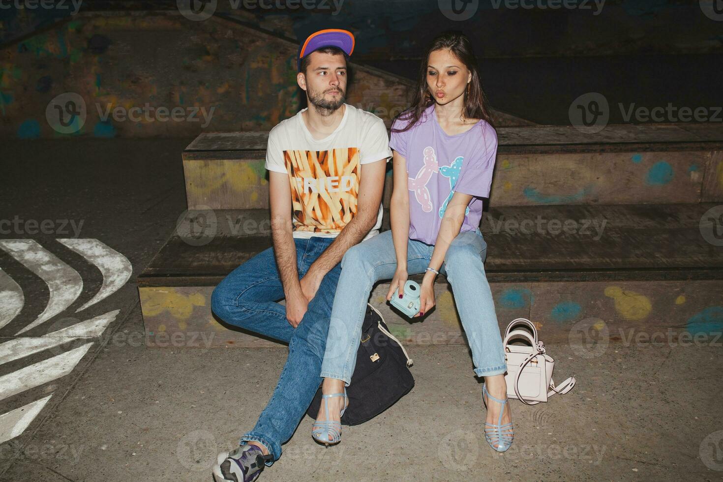 cool young stylish hipster couple in love, swag outfit, jeans, embrace, cool accessories, sitting happy, having fun photo