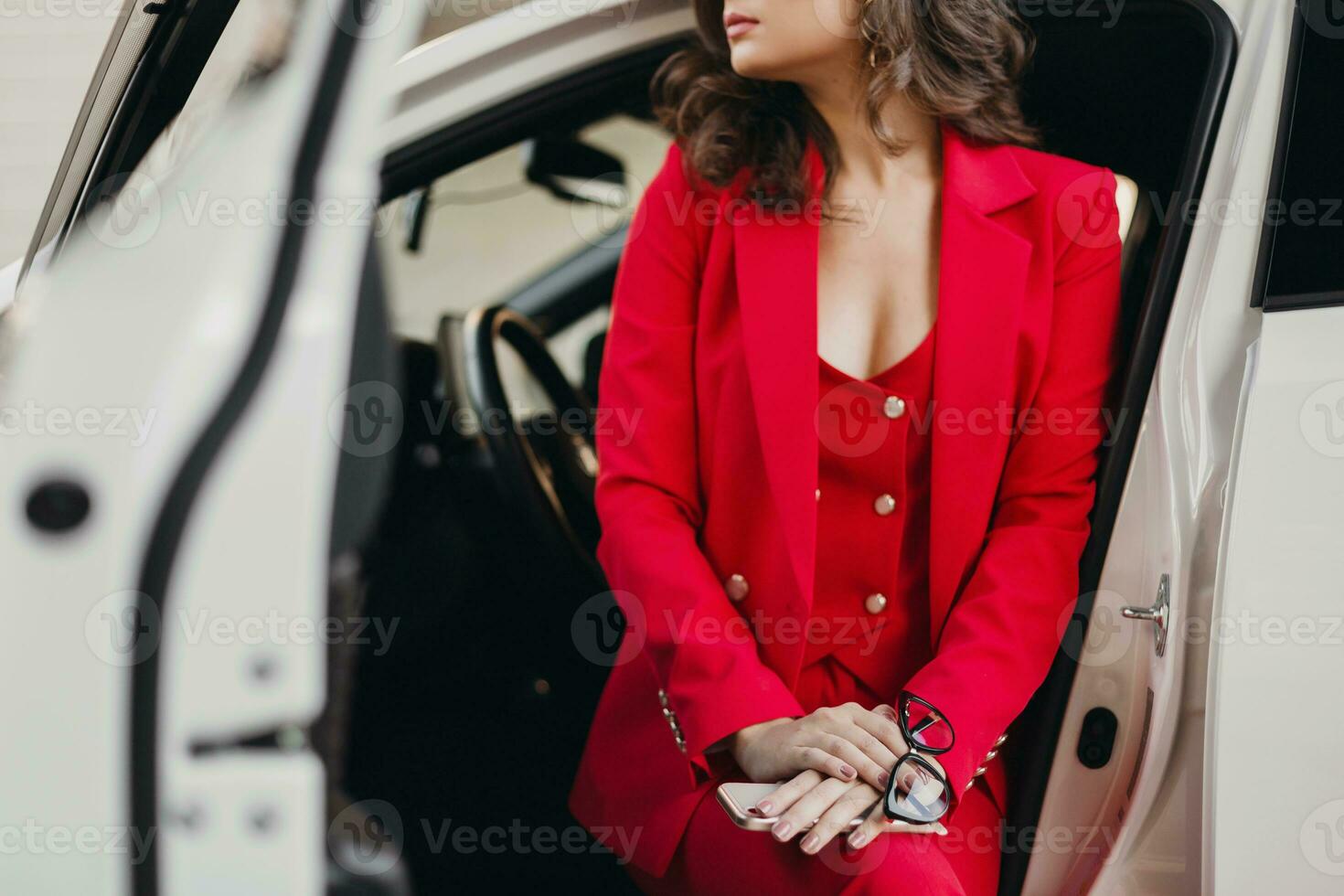 beautiful sexy rich business woman in red suit posing in white car photo