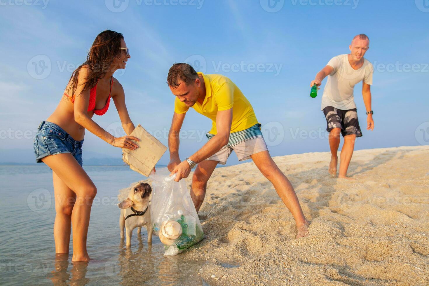 young people friends picking up trash and garbage on tropical beach photo