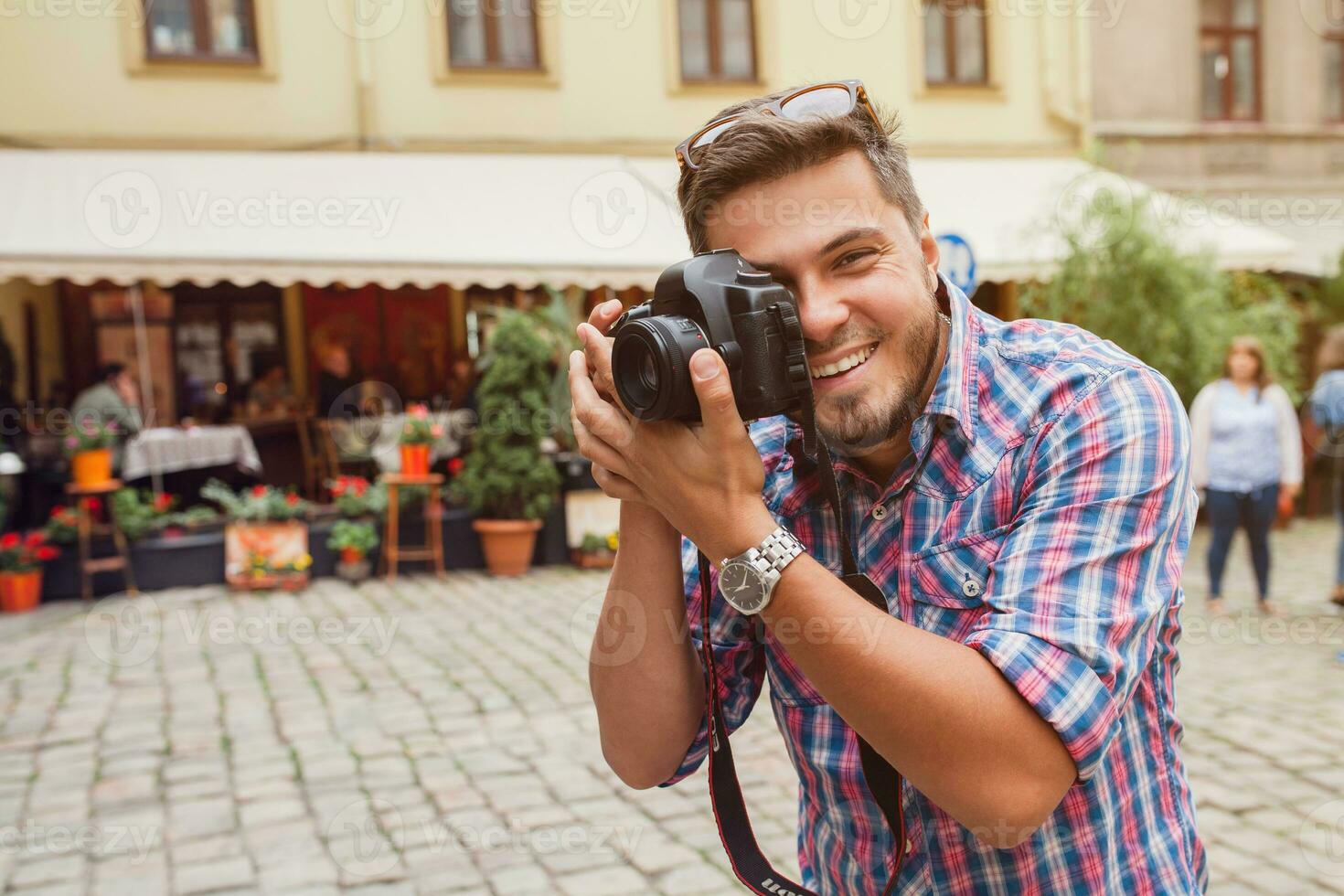 joven hermoso hipster hombre caminando con foto cámara