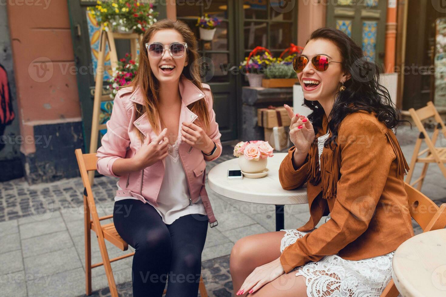 dos joven elegante mujer sentado a café foto