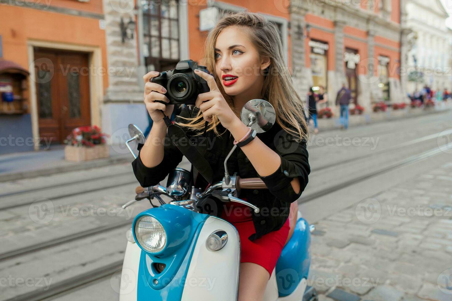 young beautiful hipster woman riding with photo camera on motorbike