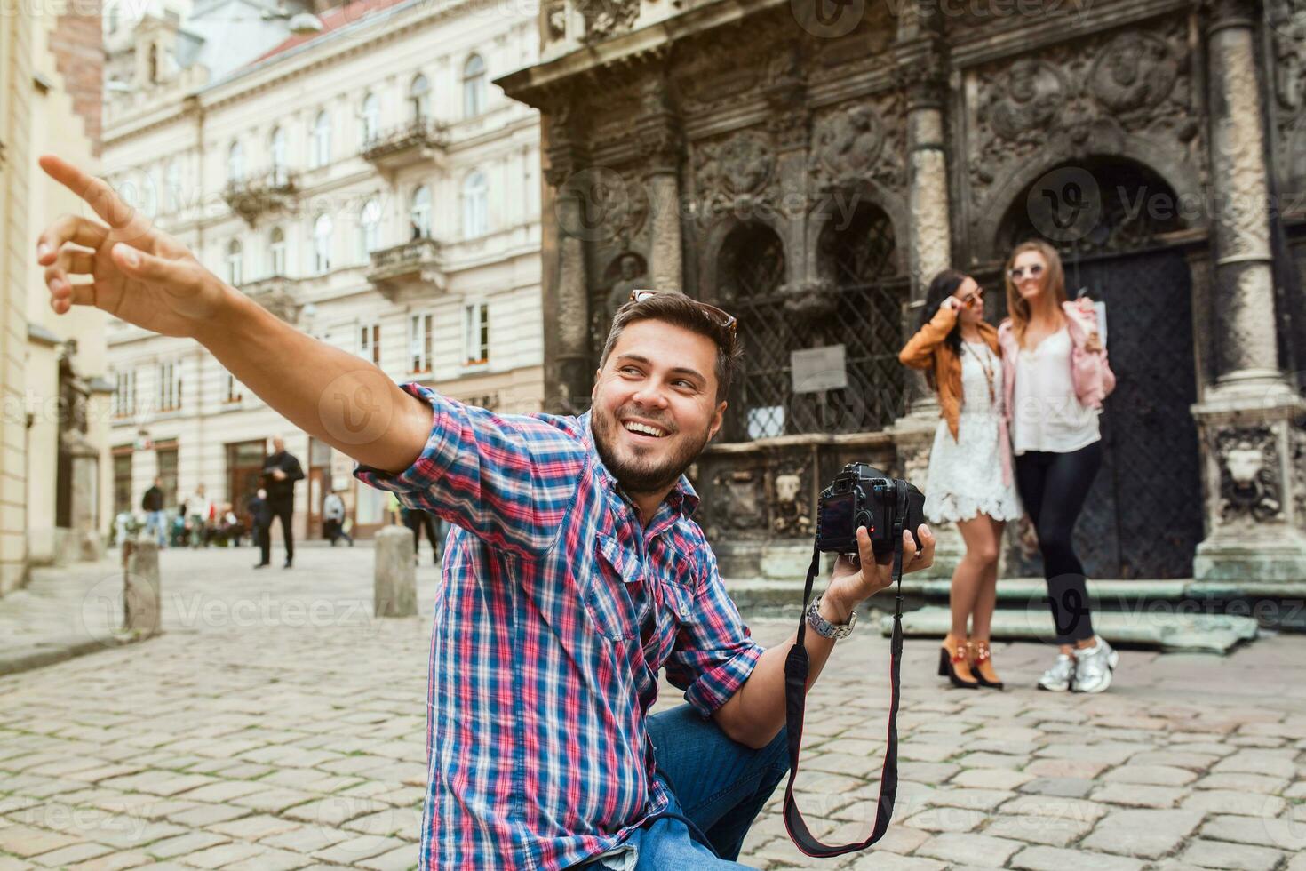 young man photographer taking pictures, holding digital photo camera