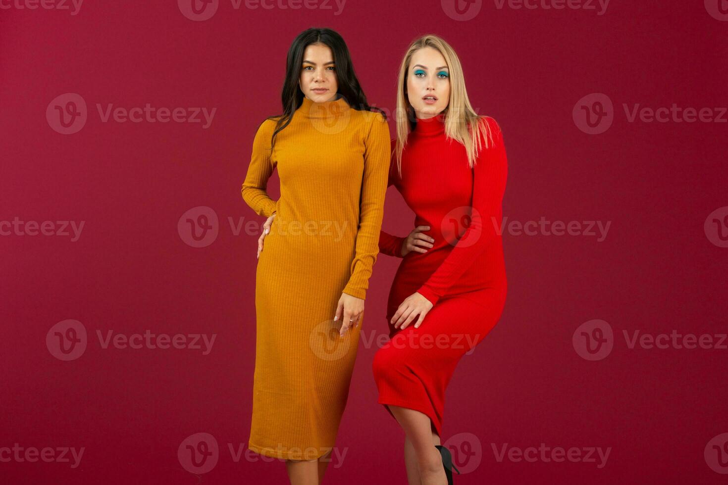 pretty stylish women in yellow and red autumn winter fashion knitted dress posing isolated on red studio background photo
