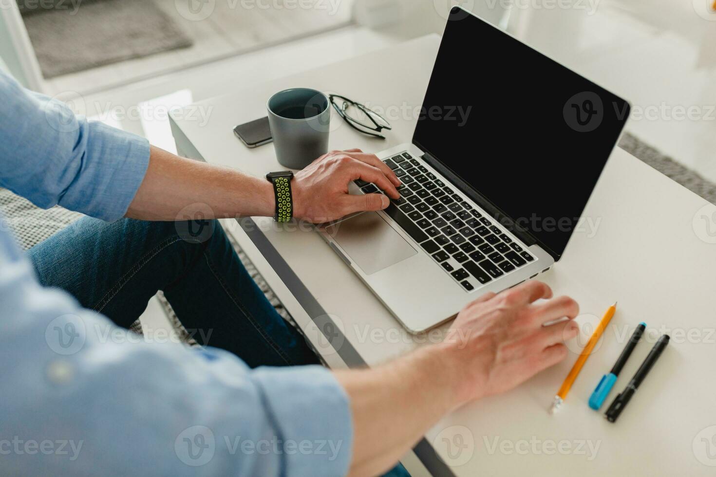 view on table workplace close-up man hands at home working typing on laptop online photo