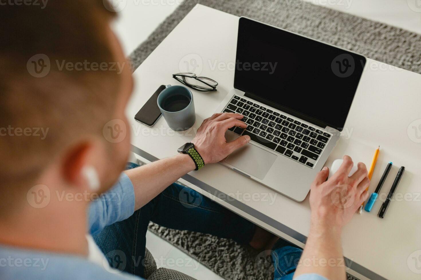 view on table workplace close-up man hands at home working typing on laptop online photo