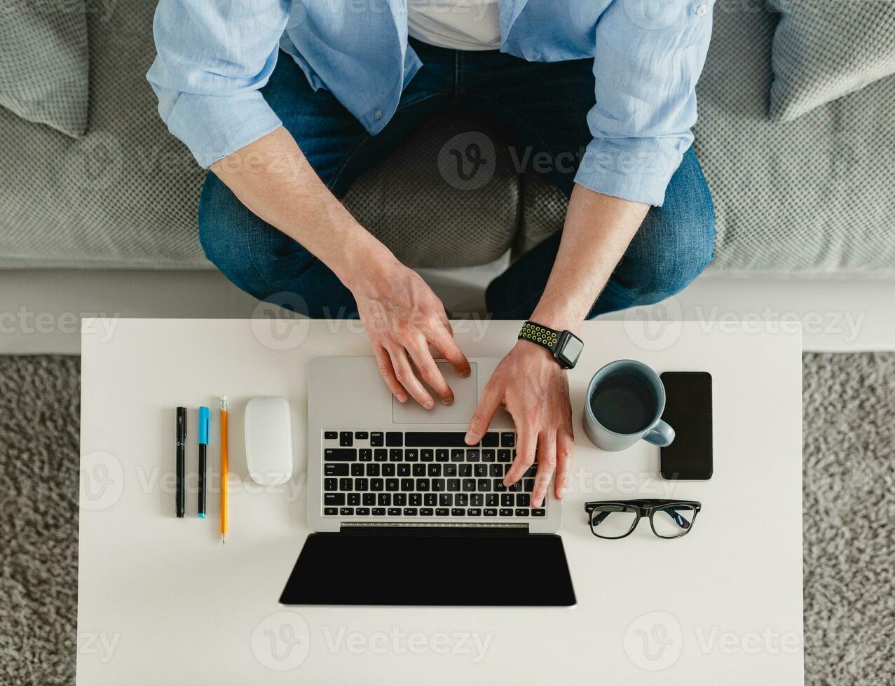 view on table workplace close-up man hands at home working typing on laptop online photo
