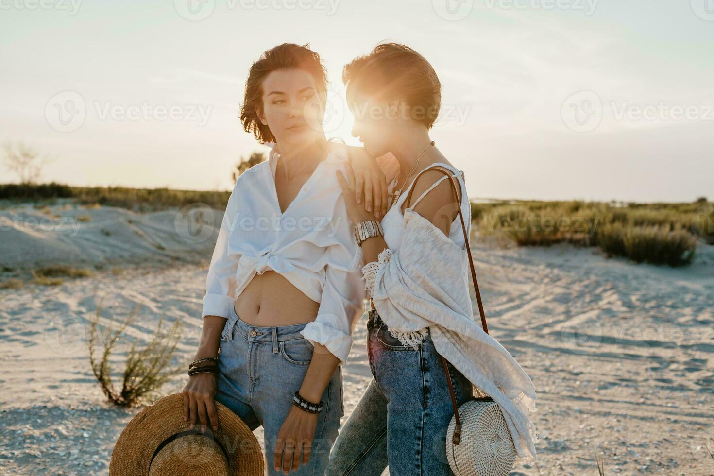 two young women having fun on the sunset beach photo