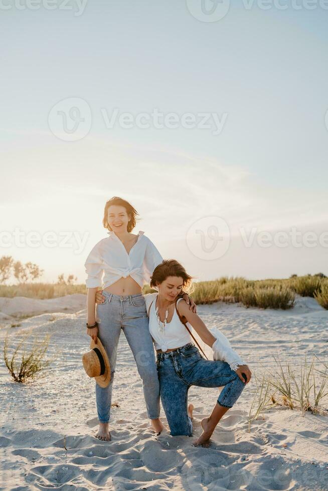 two young women having fun on the sunset beach photo