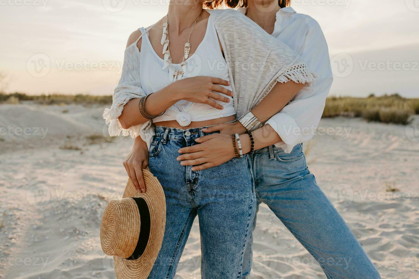 two young women having fun on the sunset beach photo