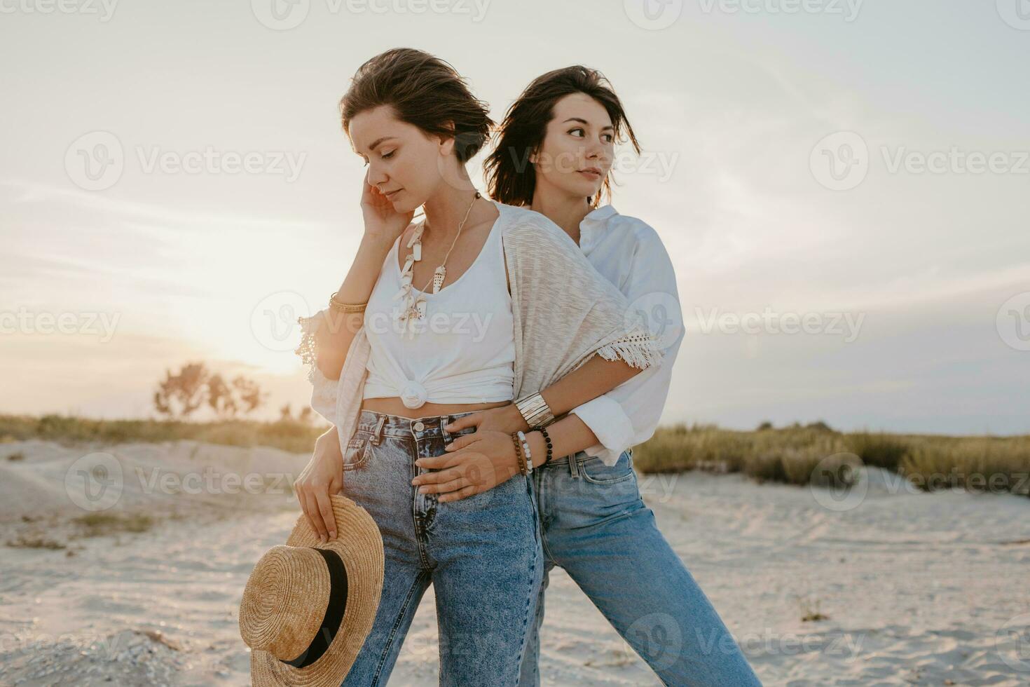 two young women having fun on the sunset beach photo
