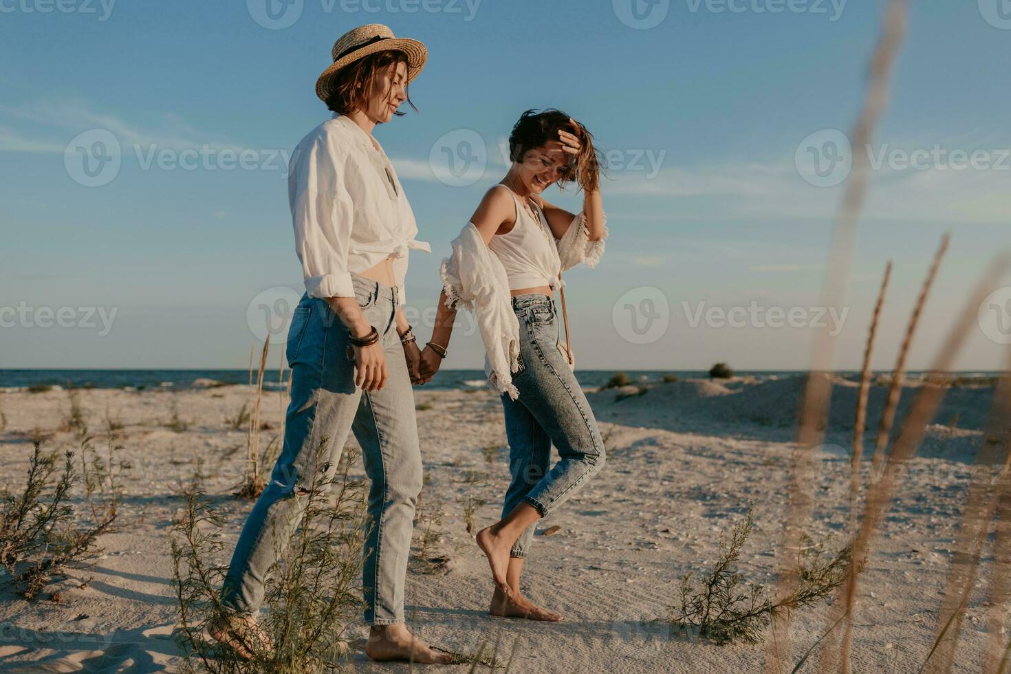 two young women having fun on the sunset beach photo