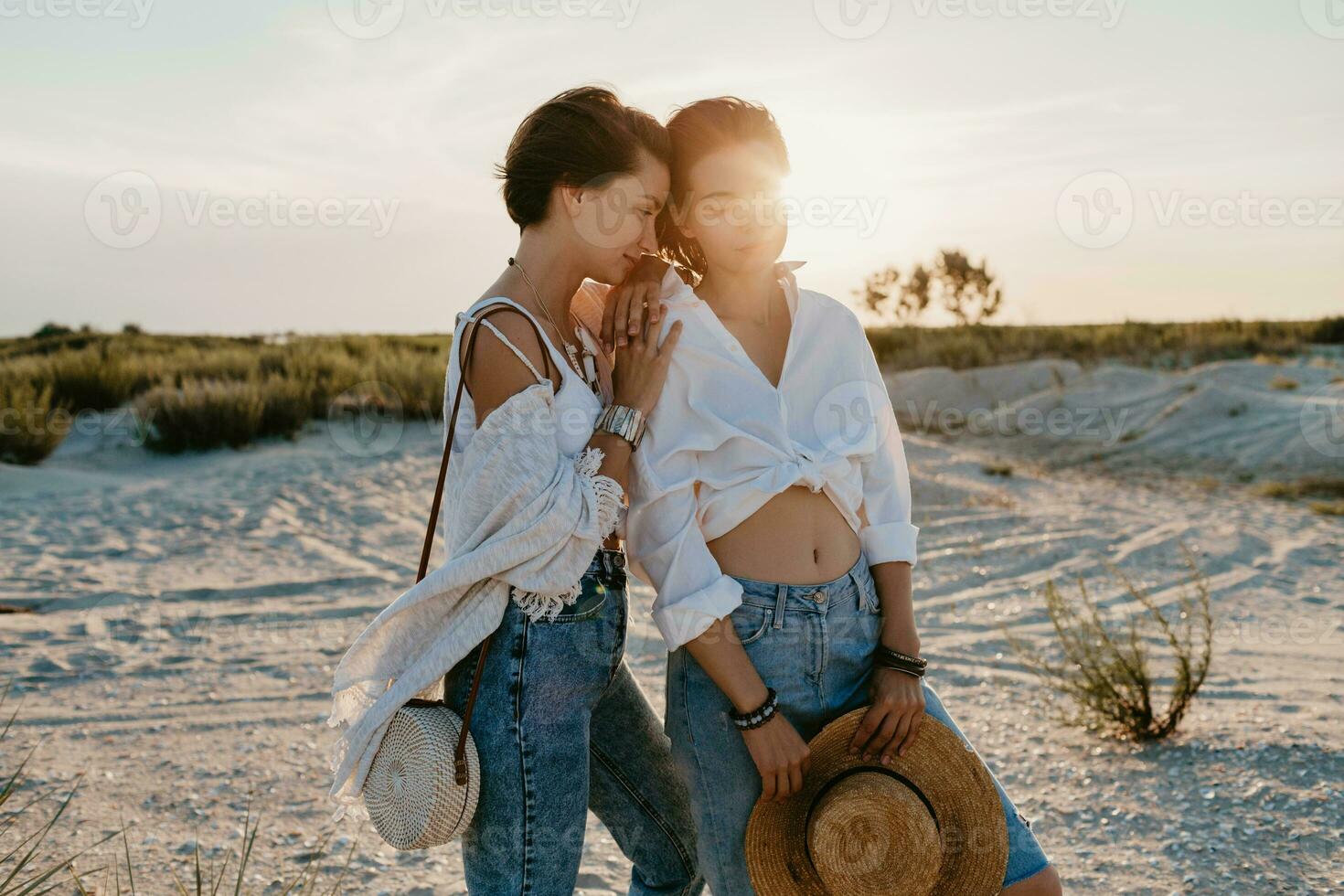 two young women having fun on the sunset beach photo