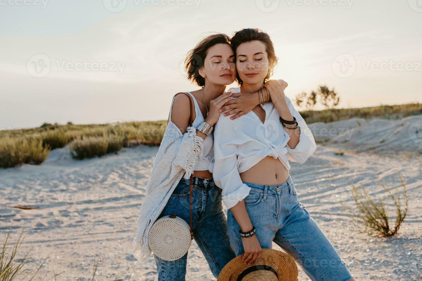 two young women having fun on the sunset beach photo