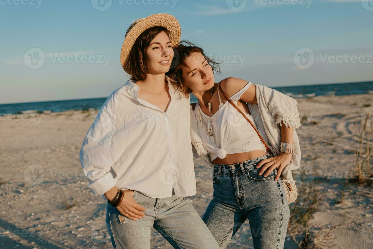 two young women having fun on the sunset beach photo