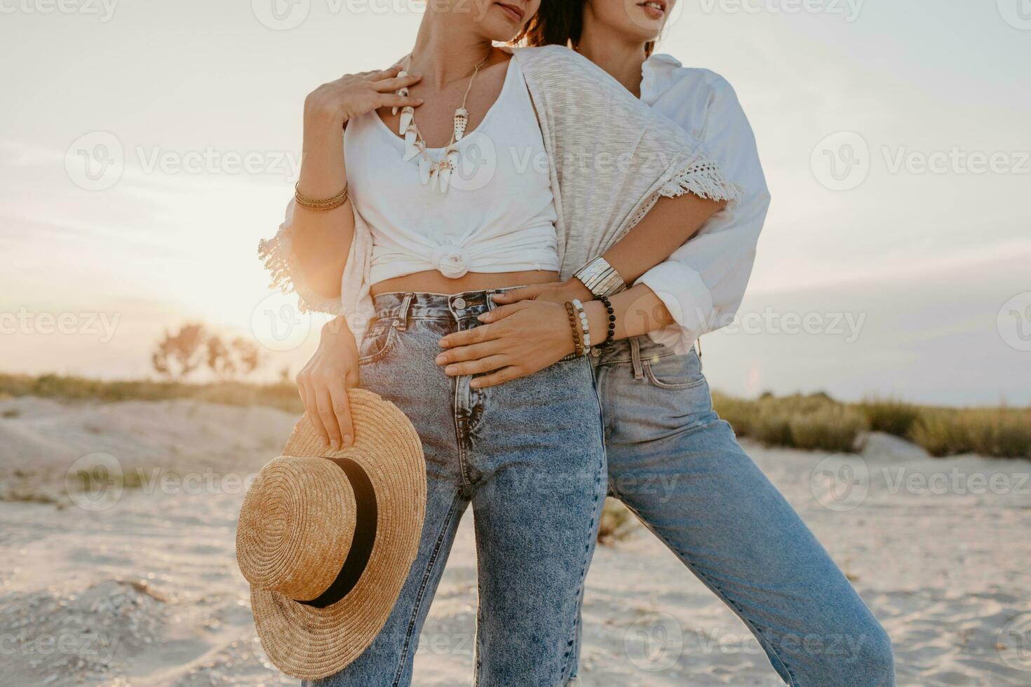 two young women having fun on the sunset beach photo