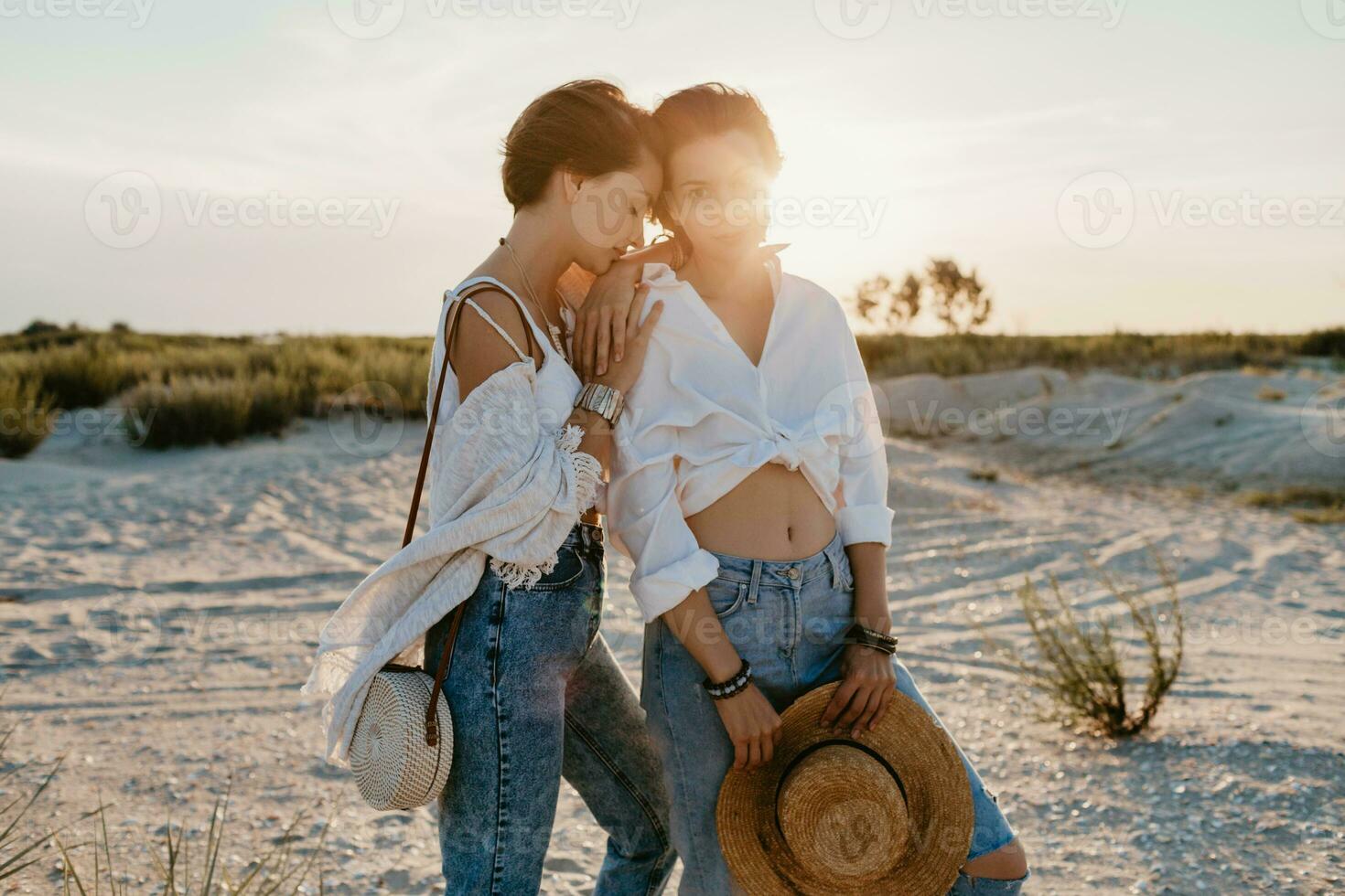 two young women having fun on the sunset beach photo