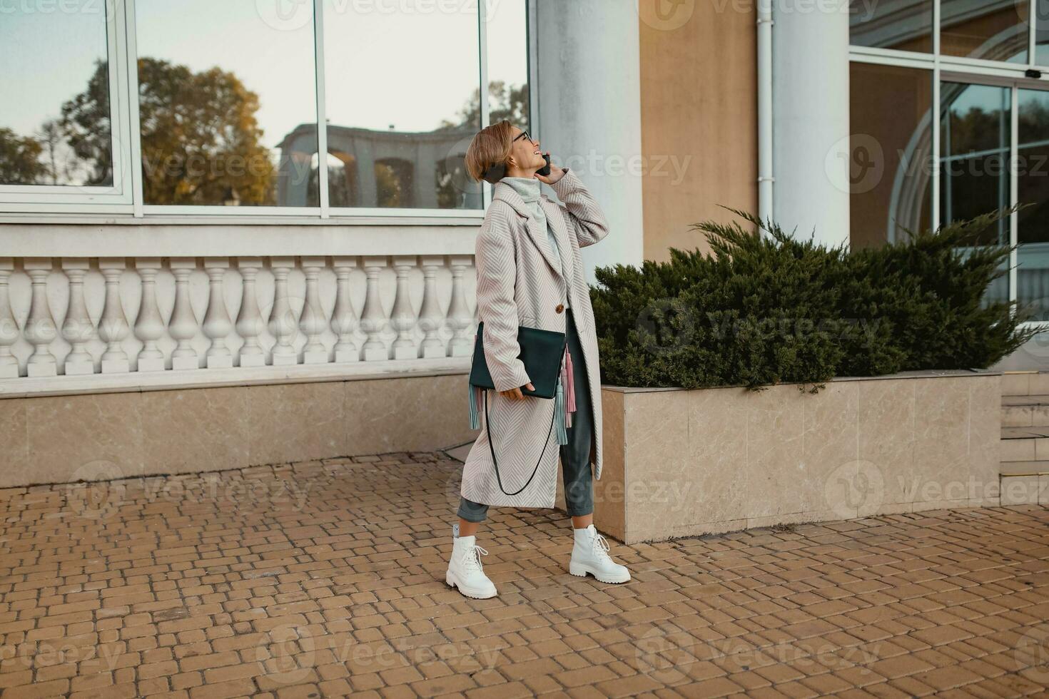 stylish fashionable woman walking in street in elegant style coat photo