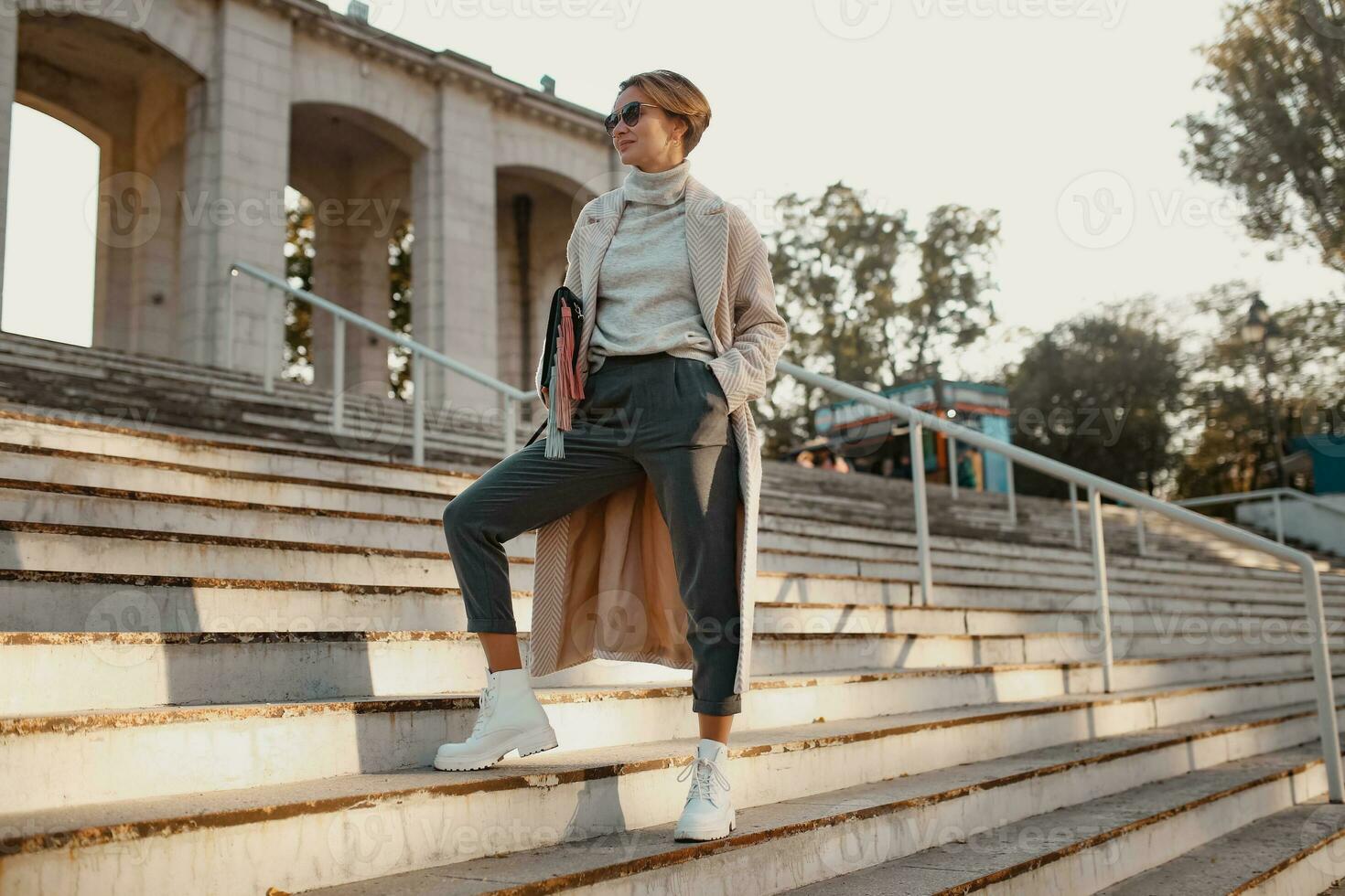 stylish fashionable woman walking in street in elegant style coat photo