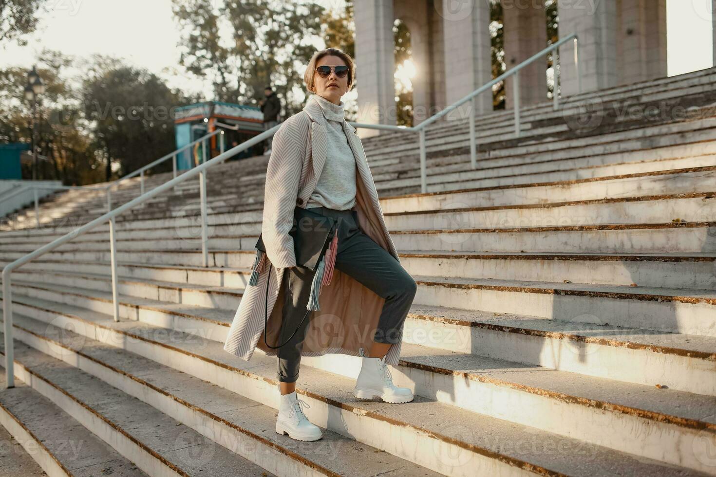 stylish fashionable woman walking in street in elegant style coat photo