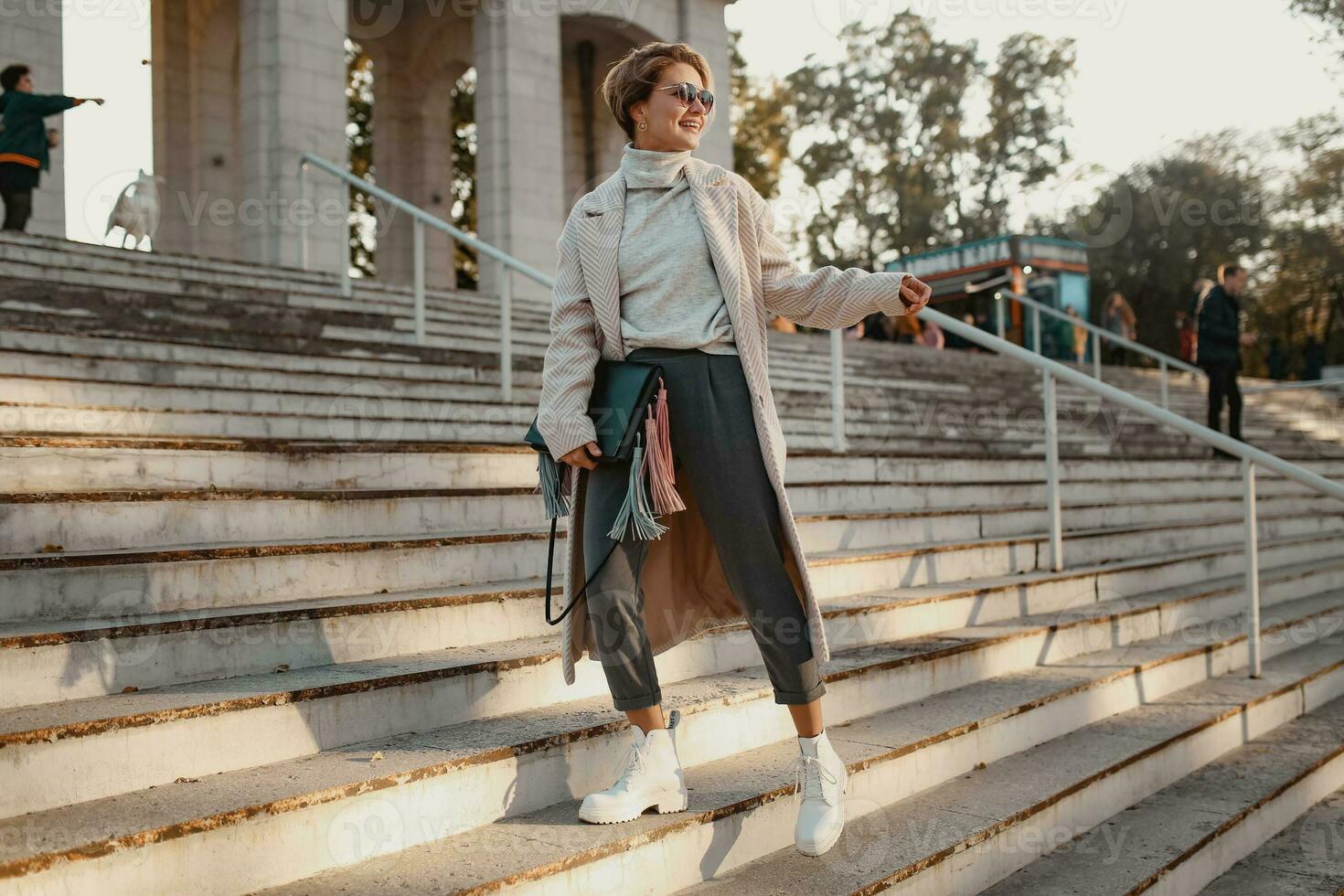 stylish fashionable woman walking in street in elegant style coat photo