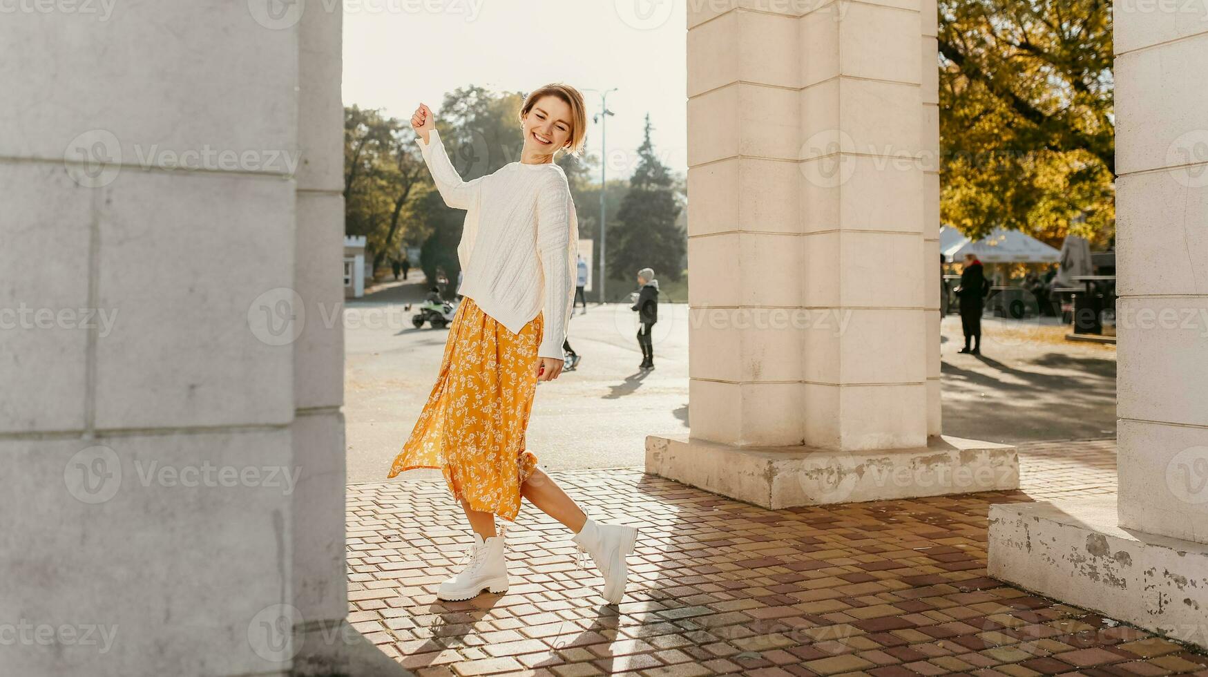 joven bonito contento sonriente mujer en amarillo impreso vestir y de punto blanco suéter foto