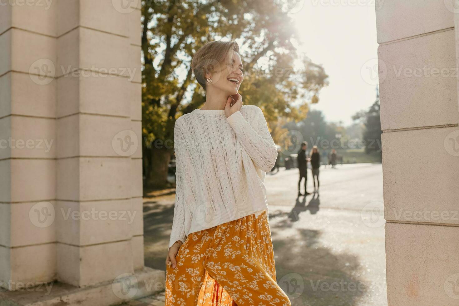 joven bonito contento sonriente mujer en amarillo impreso vestir y de punto blanco suéter foto