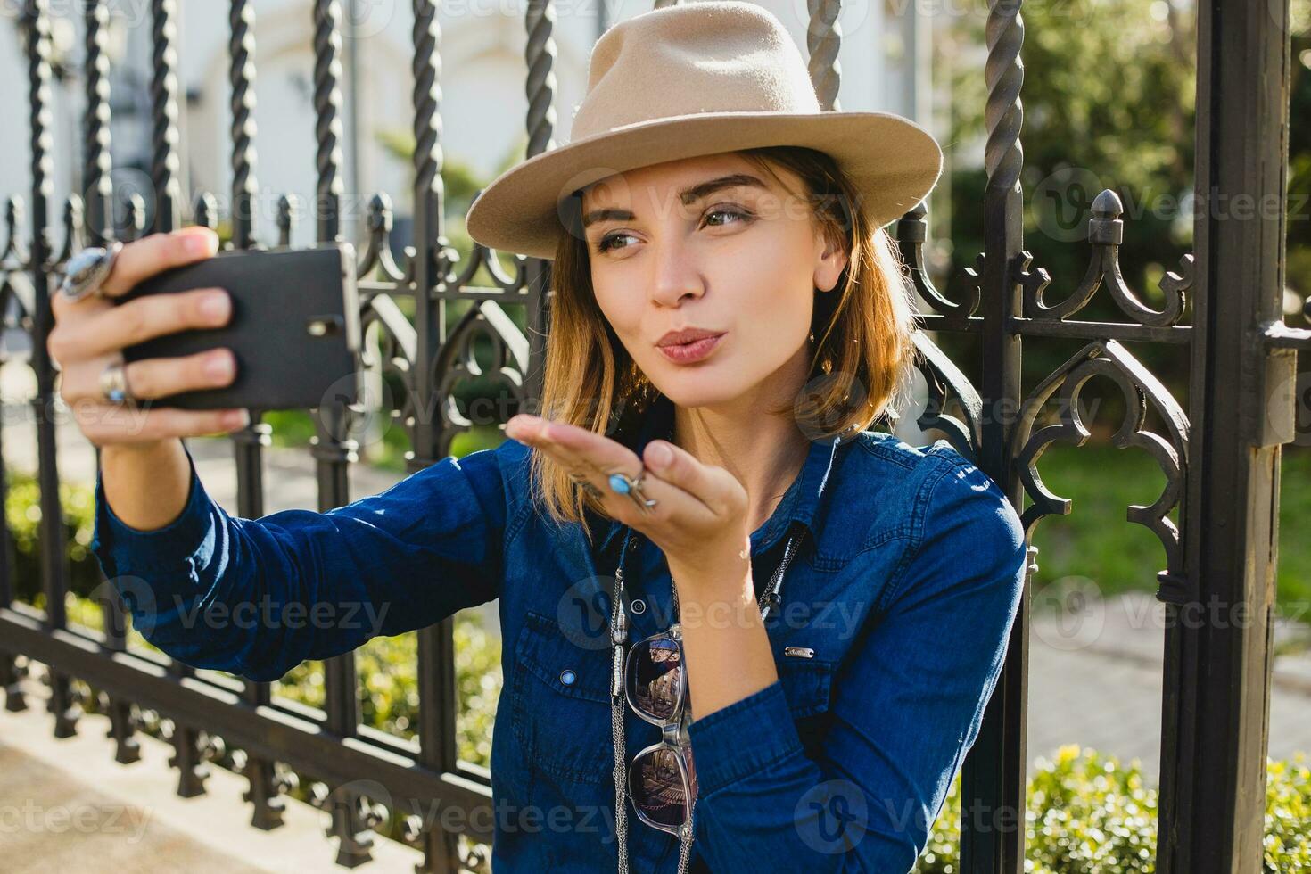 young stylish pretty happy woman smiling and holding phone photo