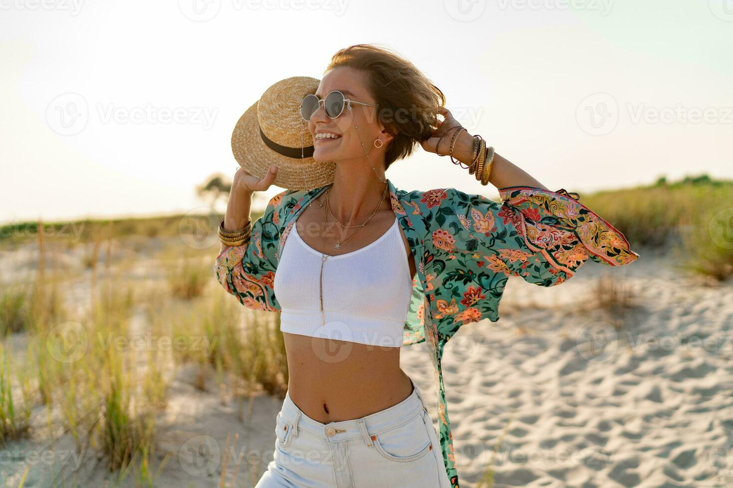 stylish attractive slim smiling woman on beach in summer style fashion trend outfit photo