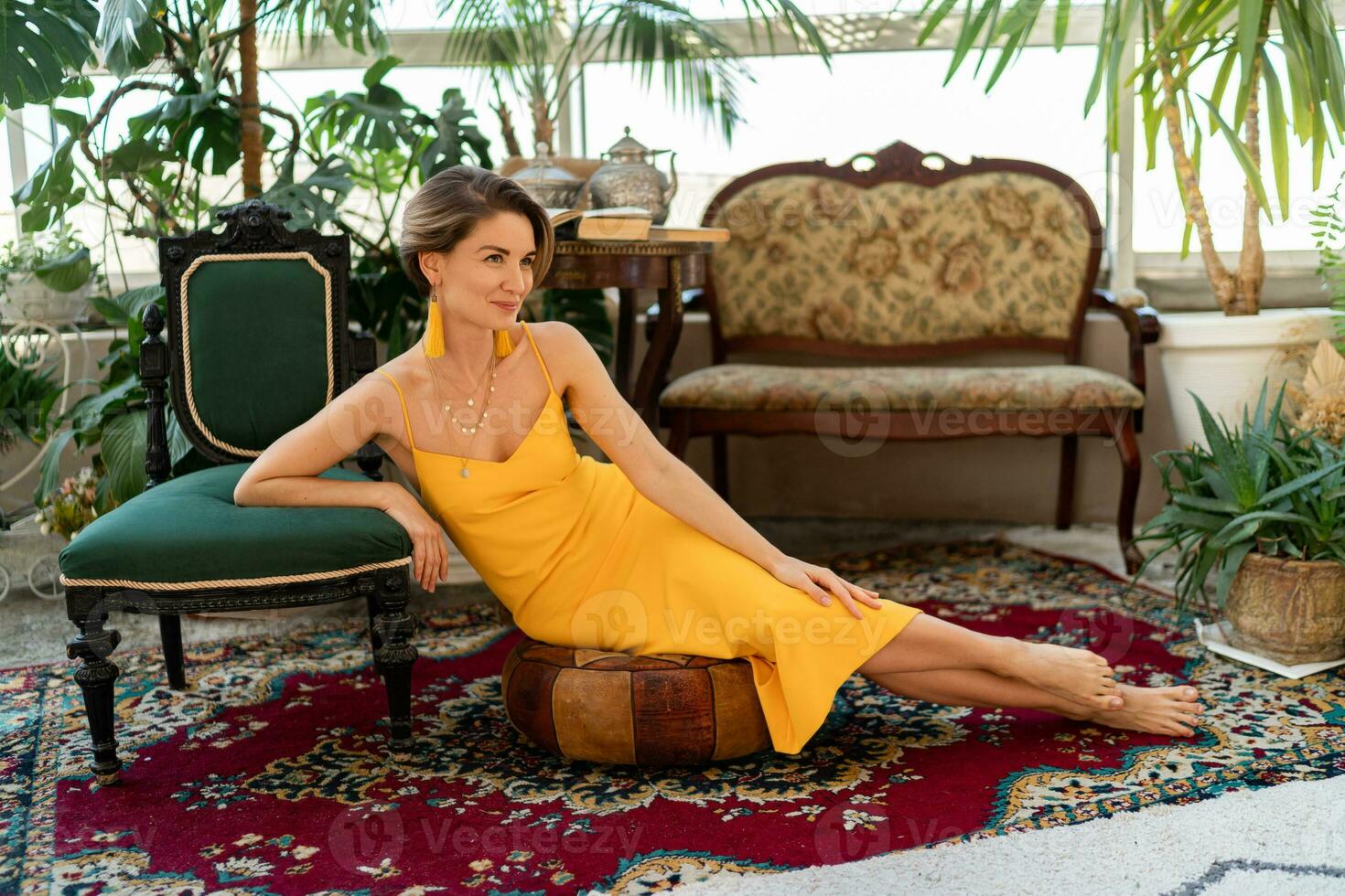 attractive woman in yellow summer dress in boho style interior room photo