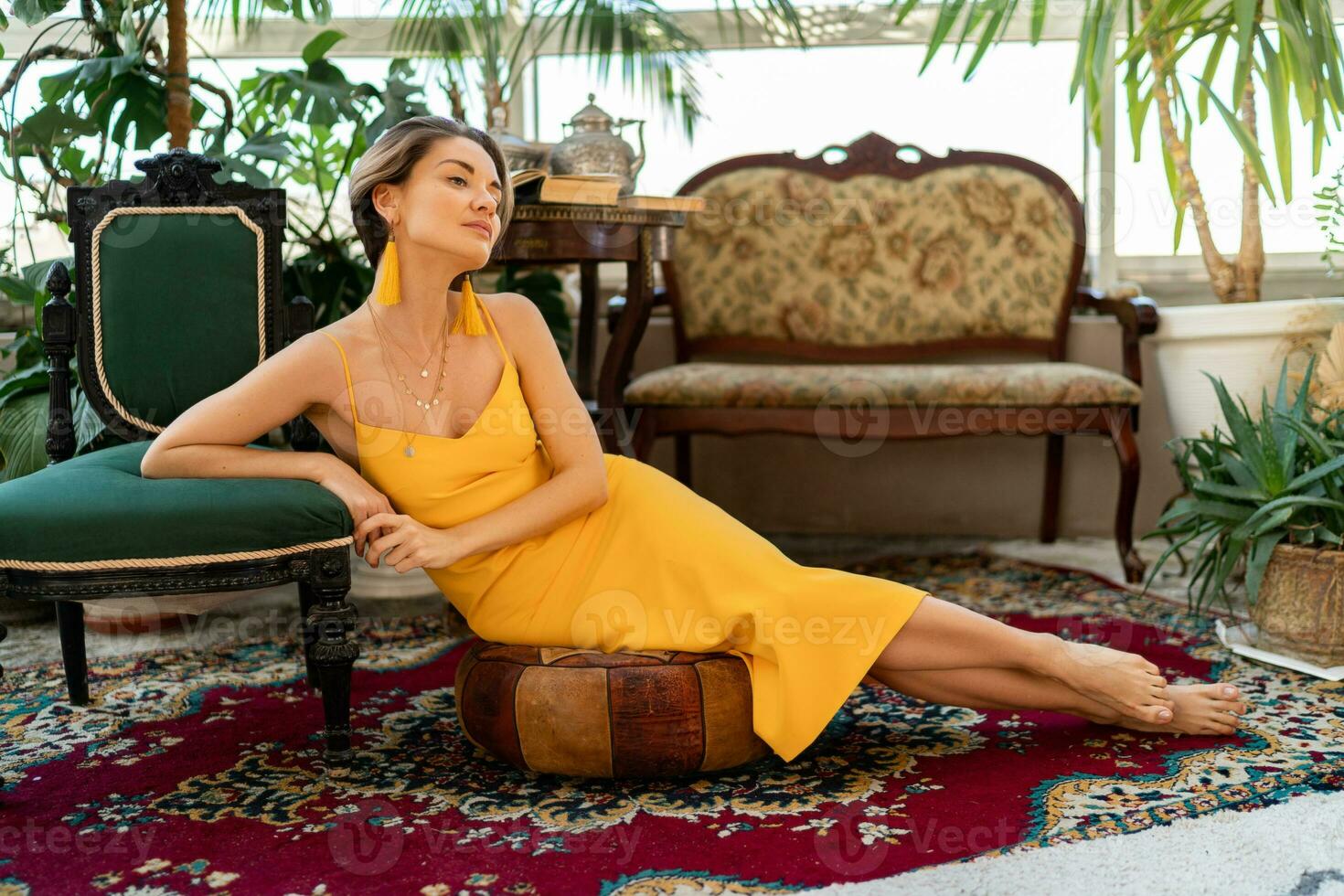 attractive woman in yellow summer dress in boho style interior room photo