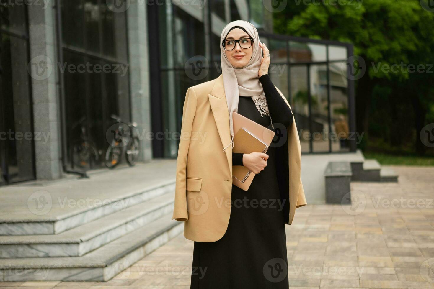 moderno elegante musulmán mujer en hijab en ciudad calle foto