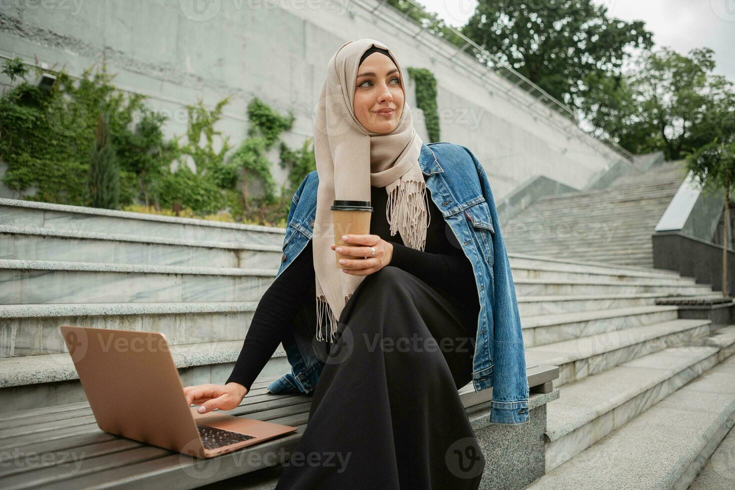 modern stylish muslim woman in hijab in city street photo