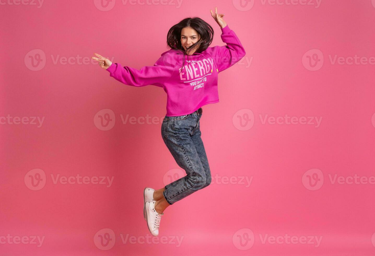 hispanic pretty woman in pink hoodie smiling jumping photo