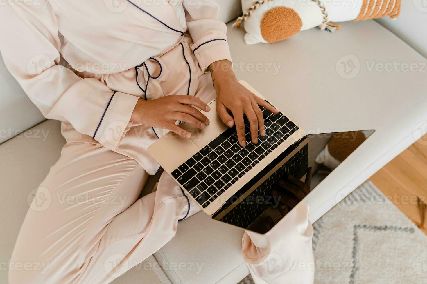 woman working on laptop at home in morning in pajamas photo