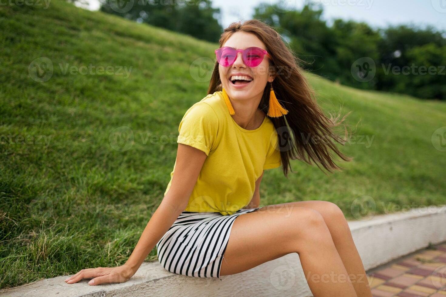 young stylish woman having fun in city park, summer style fashion trend photo