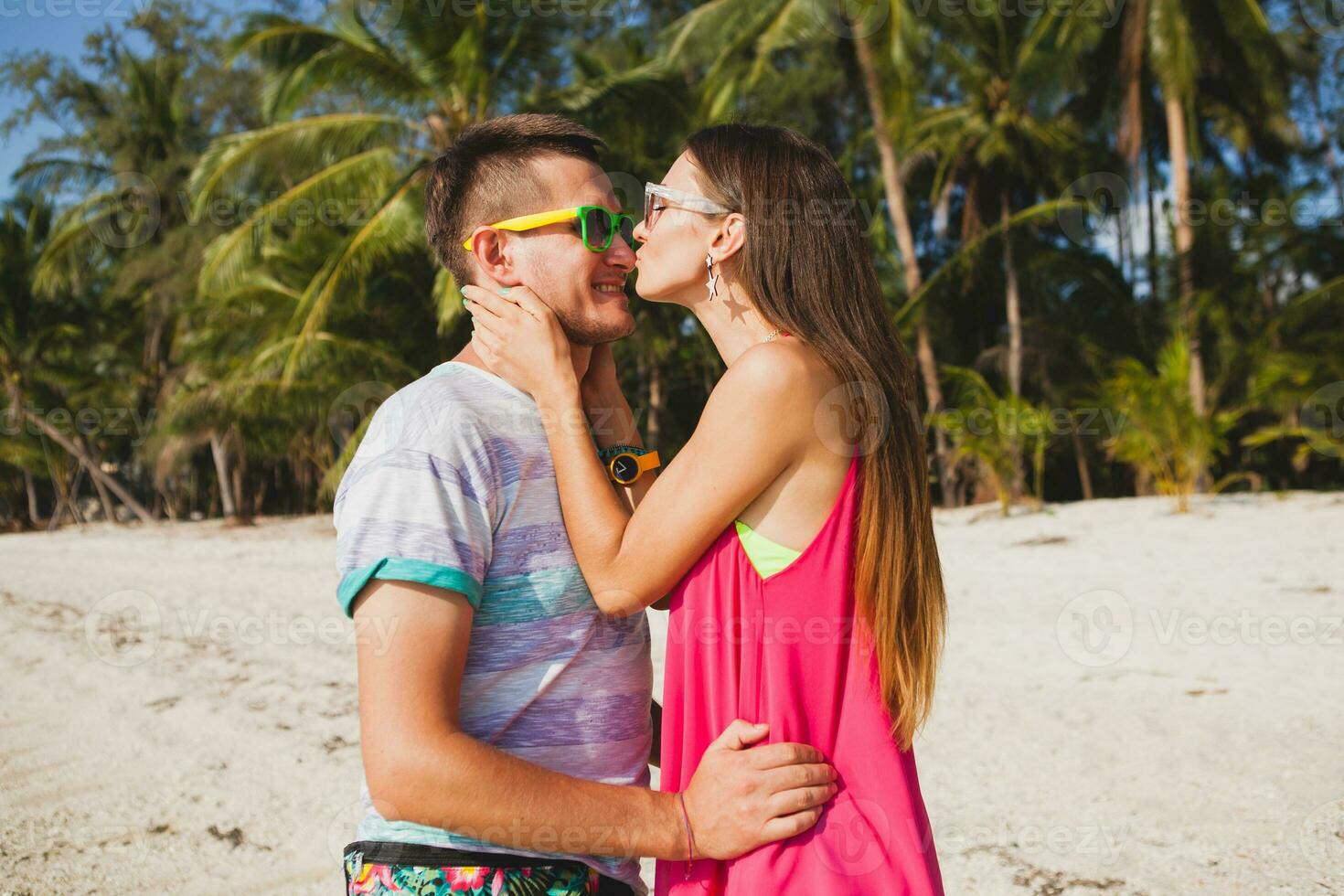 young beautiful couple walking on tropical beach photo