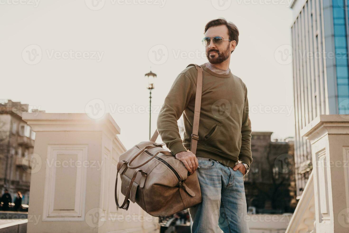 hipster man walking in street with bag photo