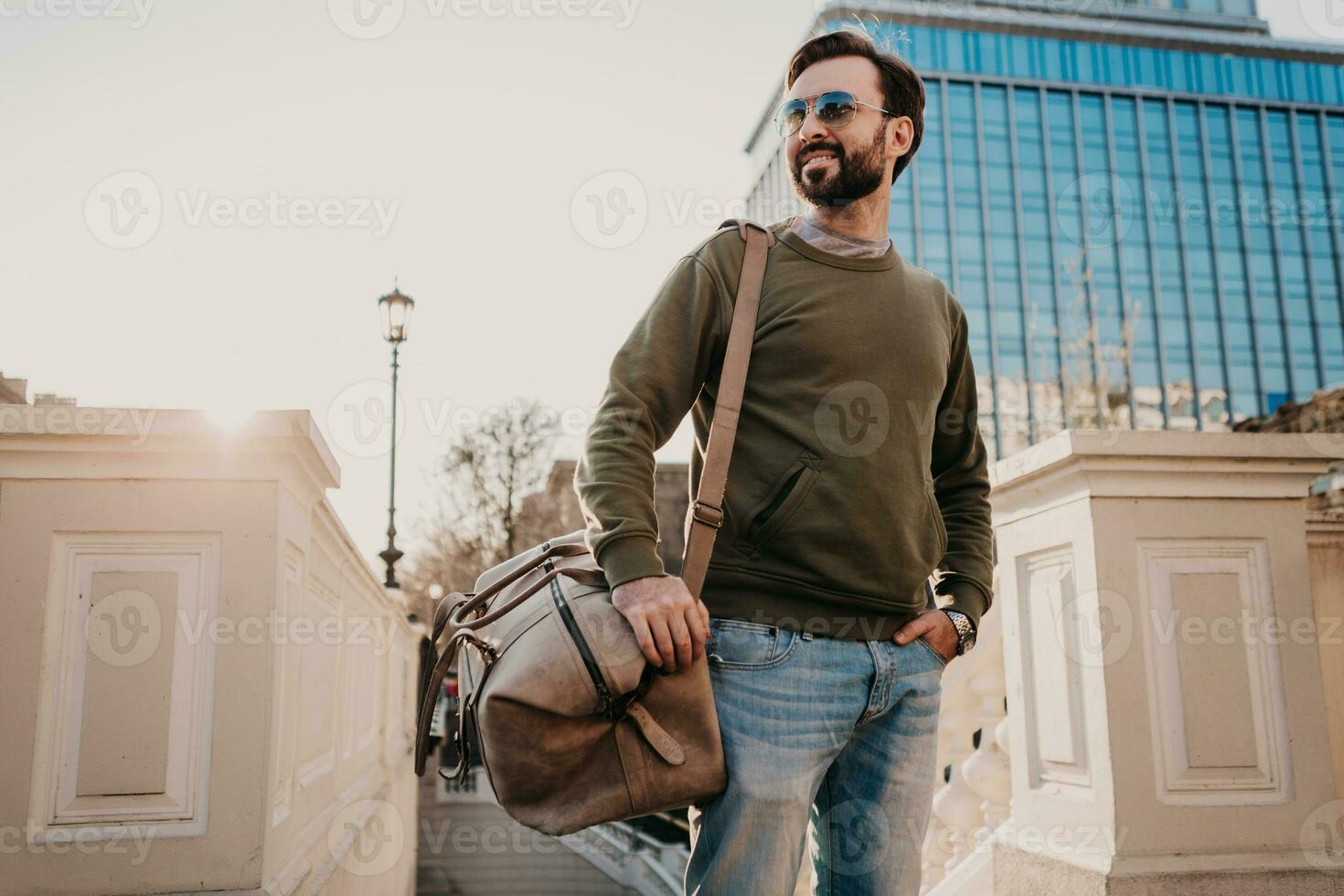 hipster man walking in street with bag photo