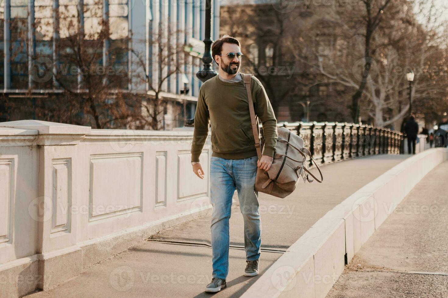 hipster man walking in street with bag photo