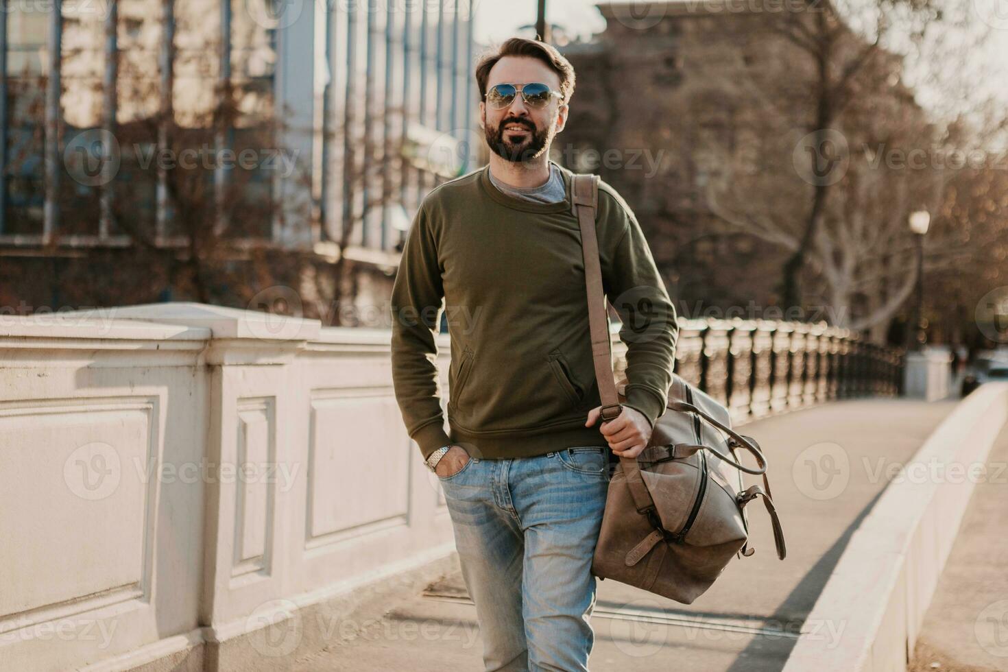 hipster man walking in street with bag photo