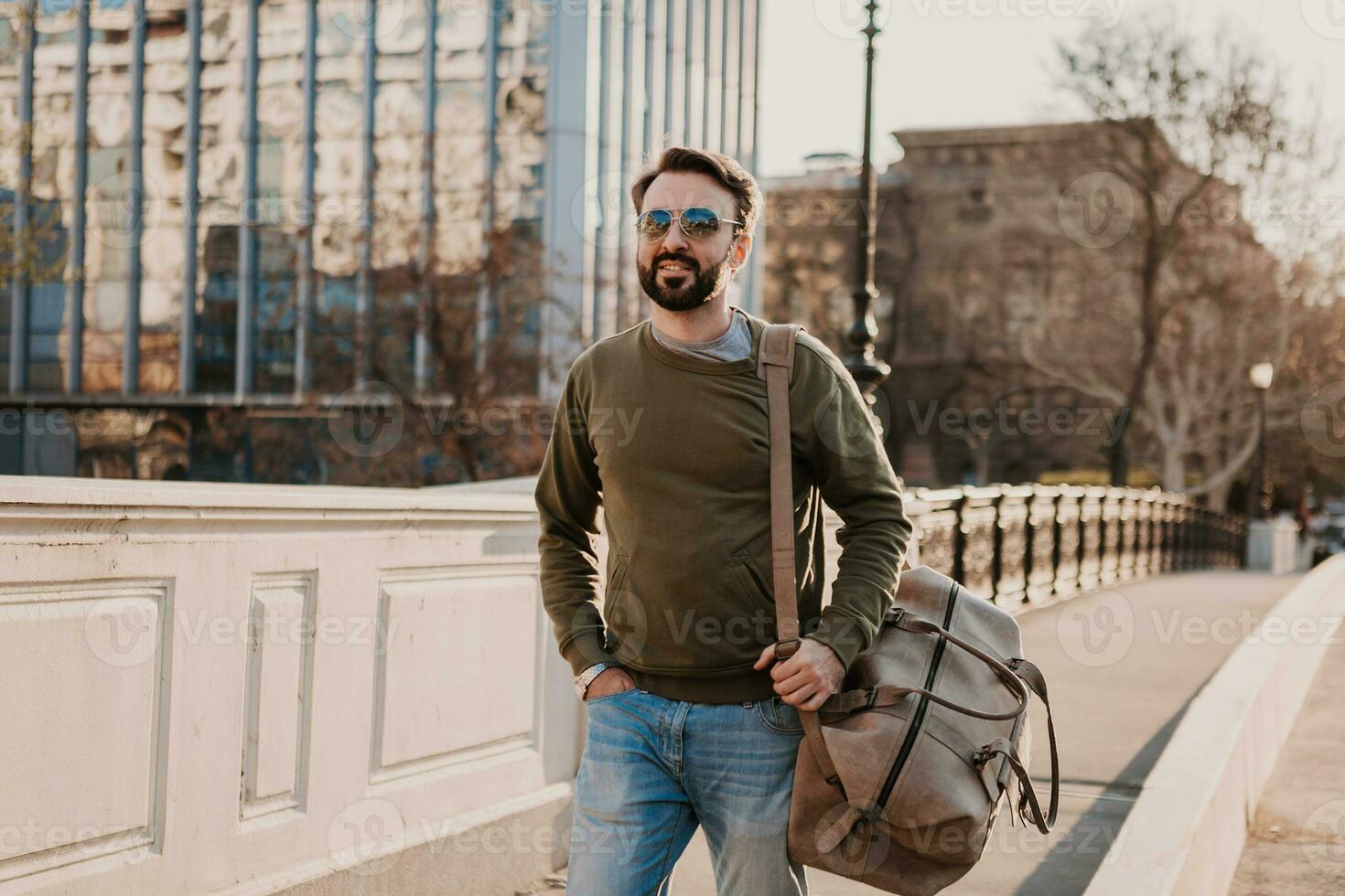 hipster man walking in street with bag photo