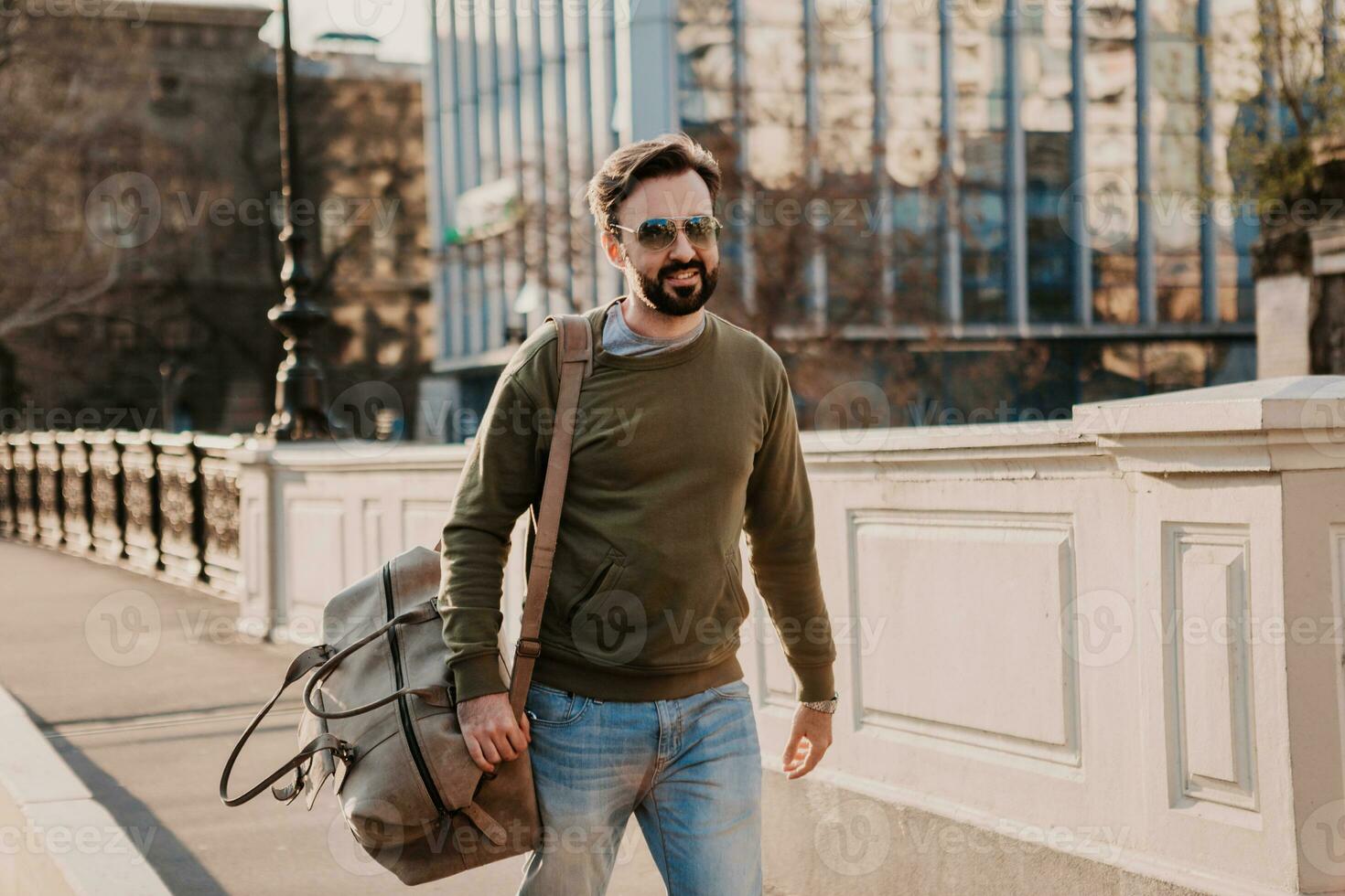 hipster man walking in street with bag photo