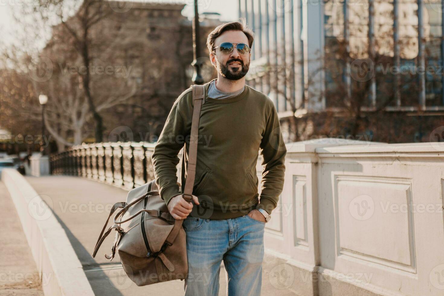 hipster man walking in street with bag photo