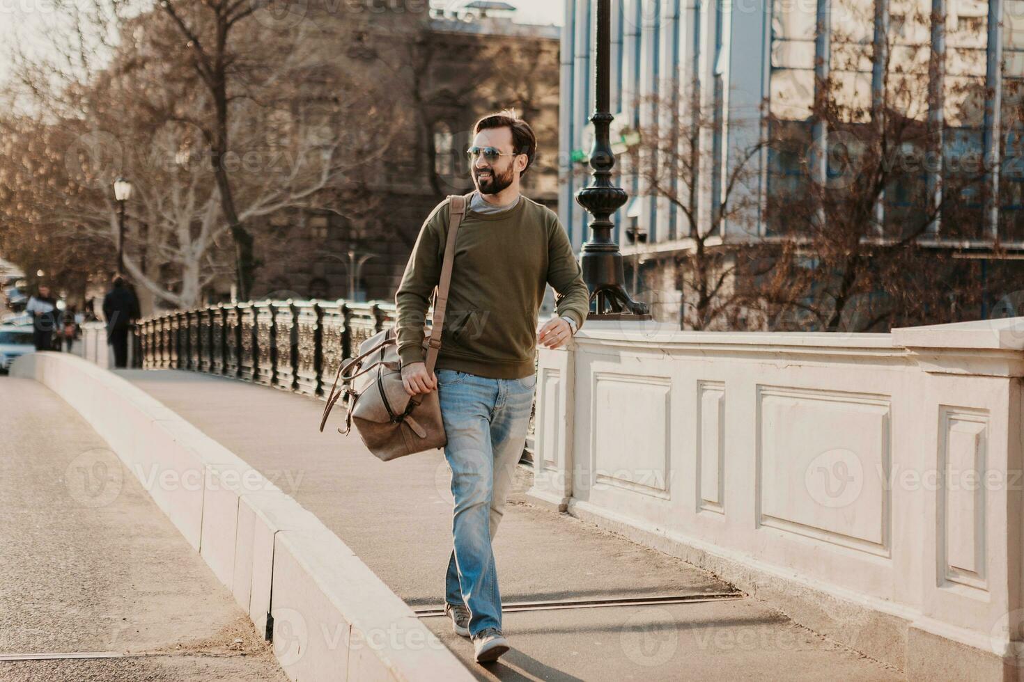 hipster man walking in street with bag photo